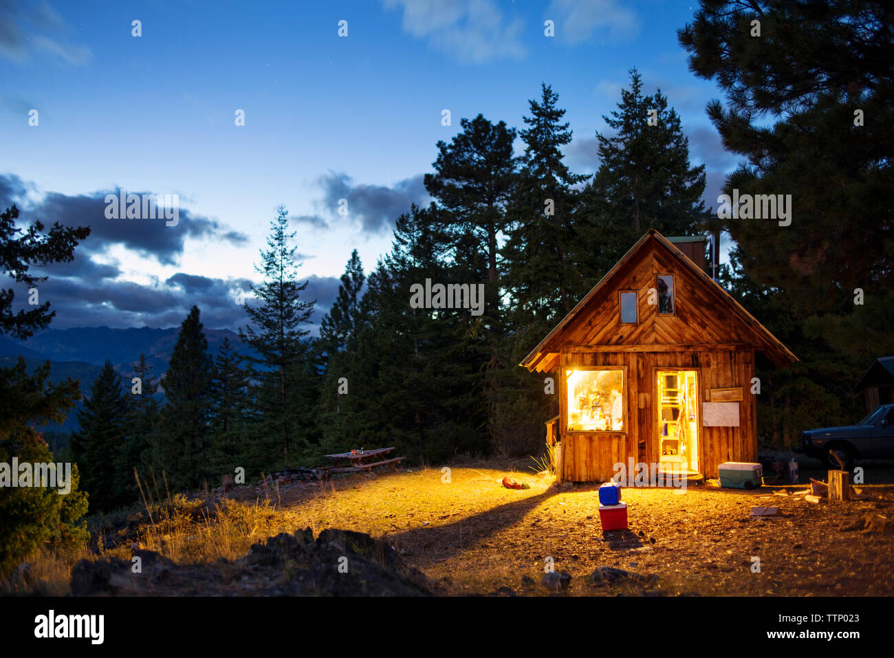 Illuminated wooden cabin in forest at night Stock Photo - Alamy