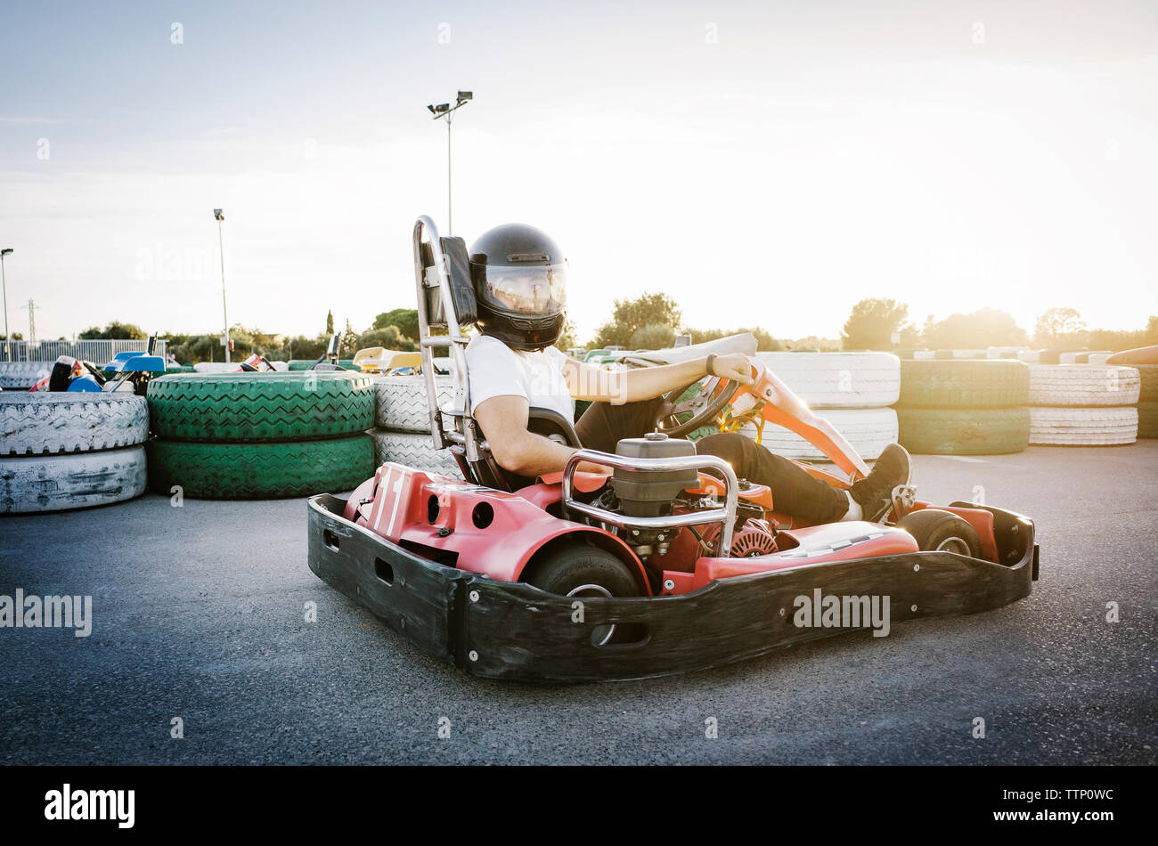Man sitting in Go-cart against sky on sunny day Stock Photo