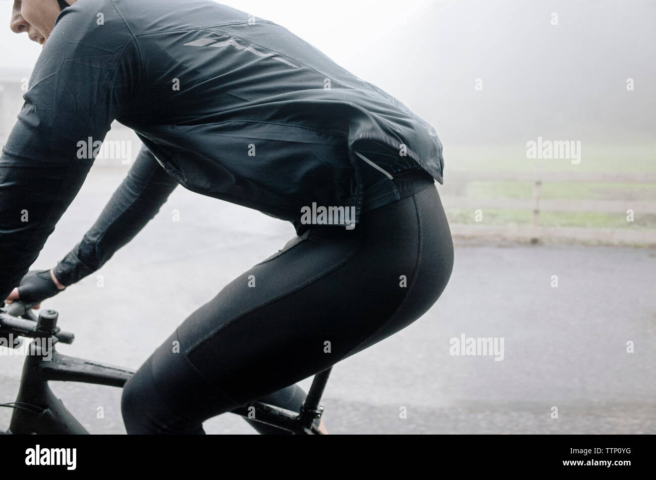 Man riding bicycle on street in foggy weather Stock Photo