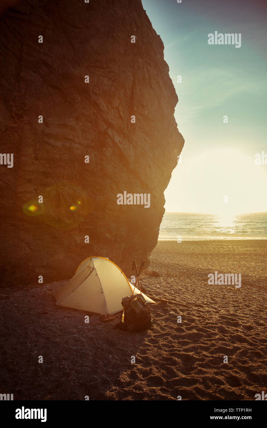 Tent by cliff on beach during sunset Stock Photo