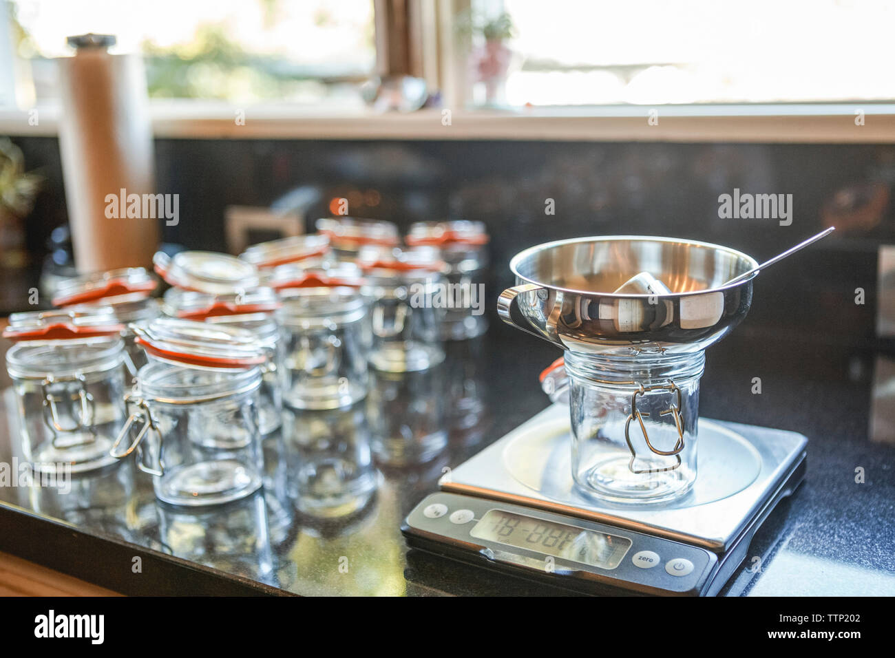 Weight scale by empty mason jars at kitchen counter Stock Photo