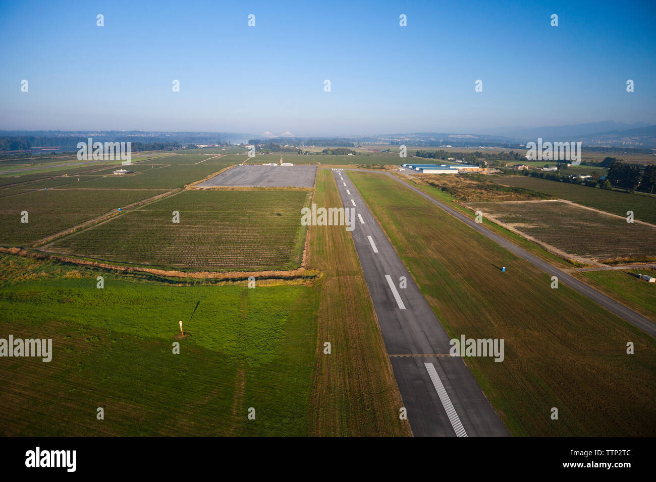 Aerial view of runway amidst field against sky Stock Photo