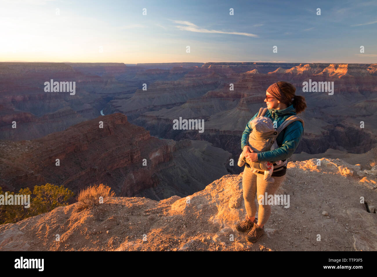 Mother with daughter standing at Grand Canyon National Park against sky during sunset Stock Photo