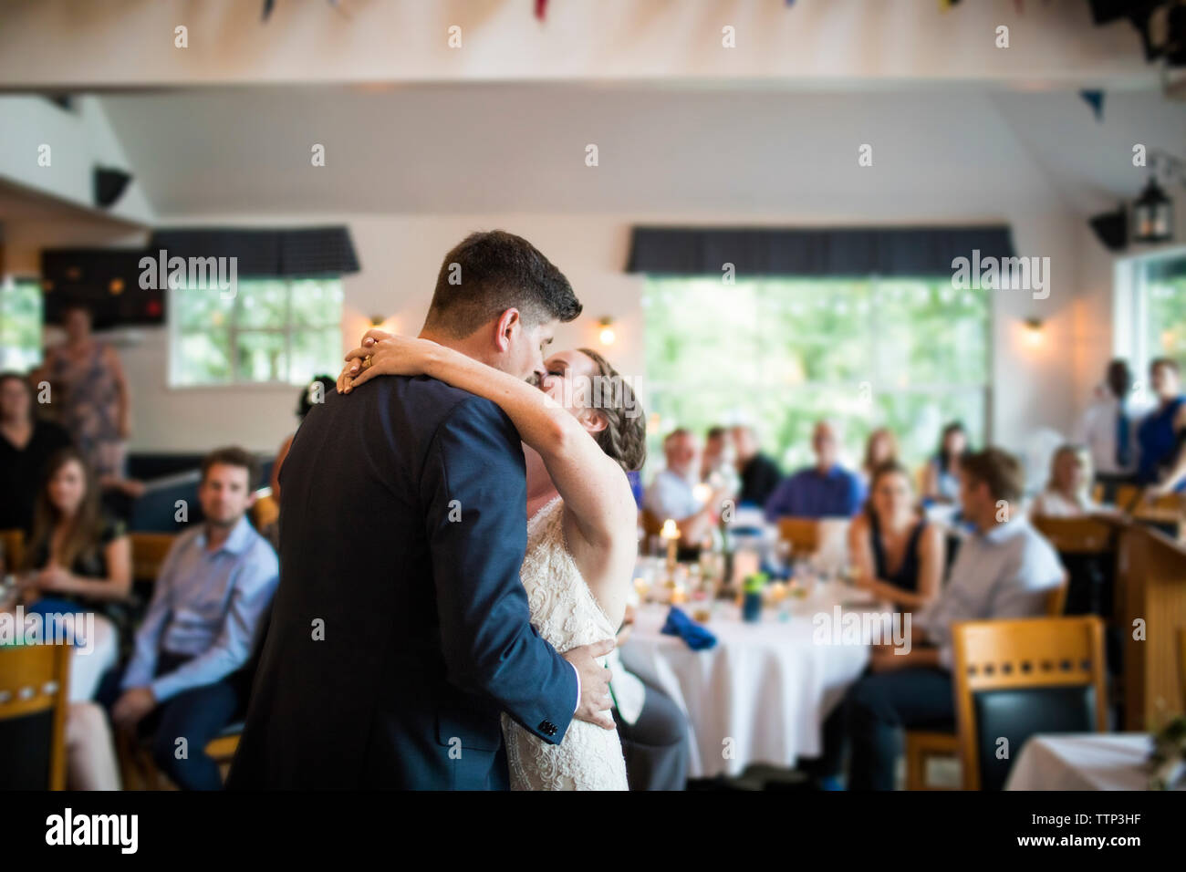 Newlywed couple kissing while dancing in wedding ceremony at restaurant Stock Photo