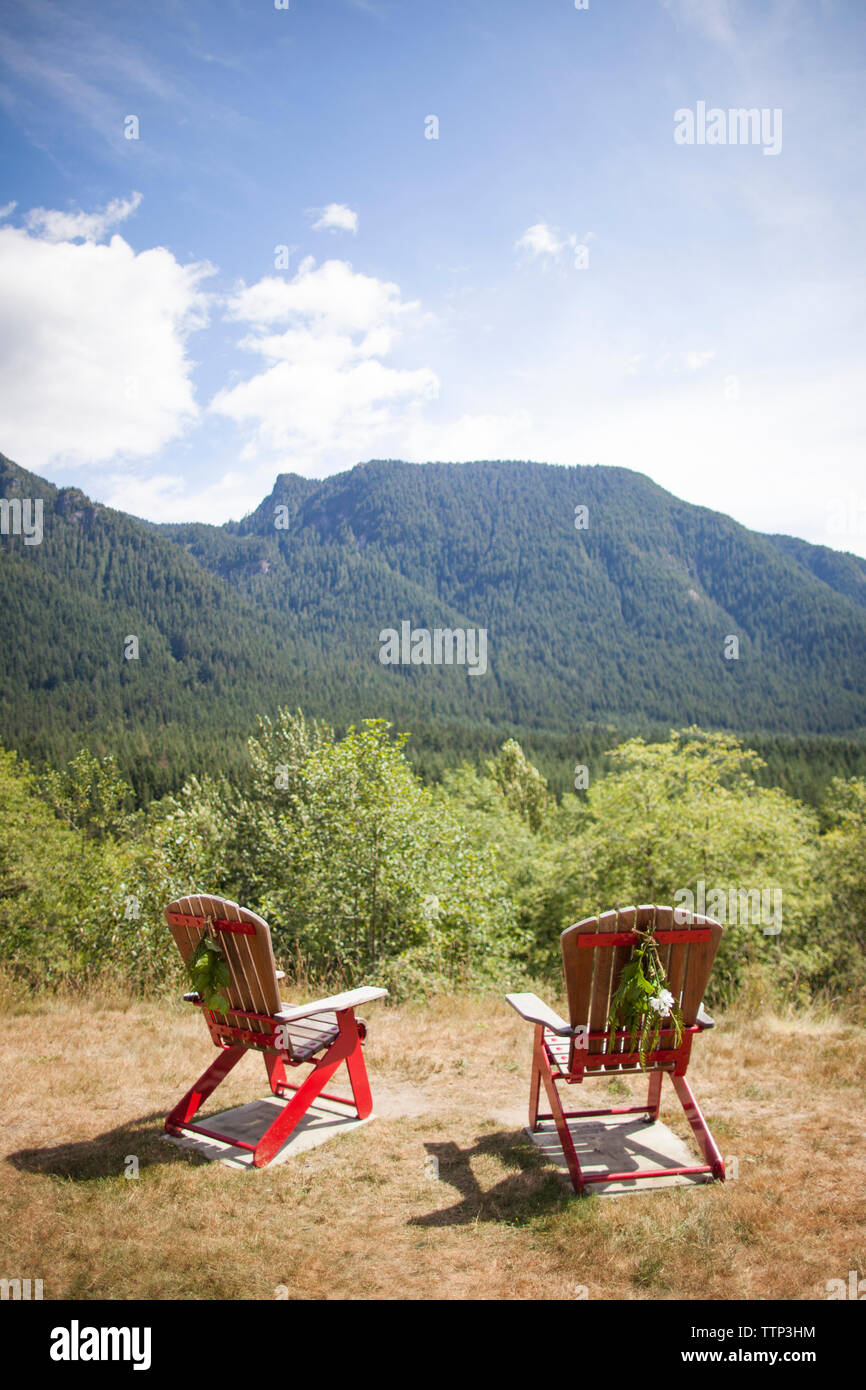 Empty wooden chairs on field against sky during wedding ceremony Stock Photo