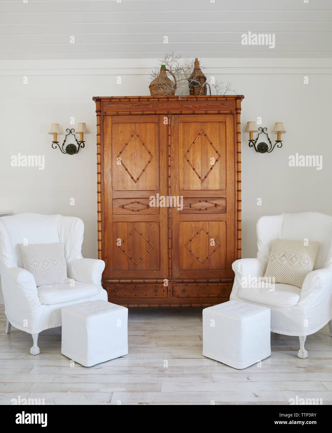 Armchairs and cupboard against wall in luxury cottage Stock Photo