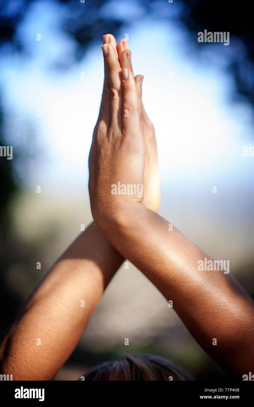 Woman with hands clasped doing yoga outdoors Stock Photo