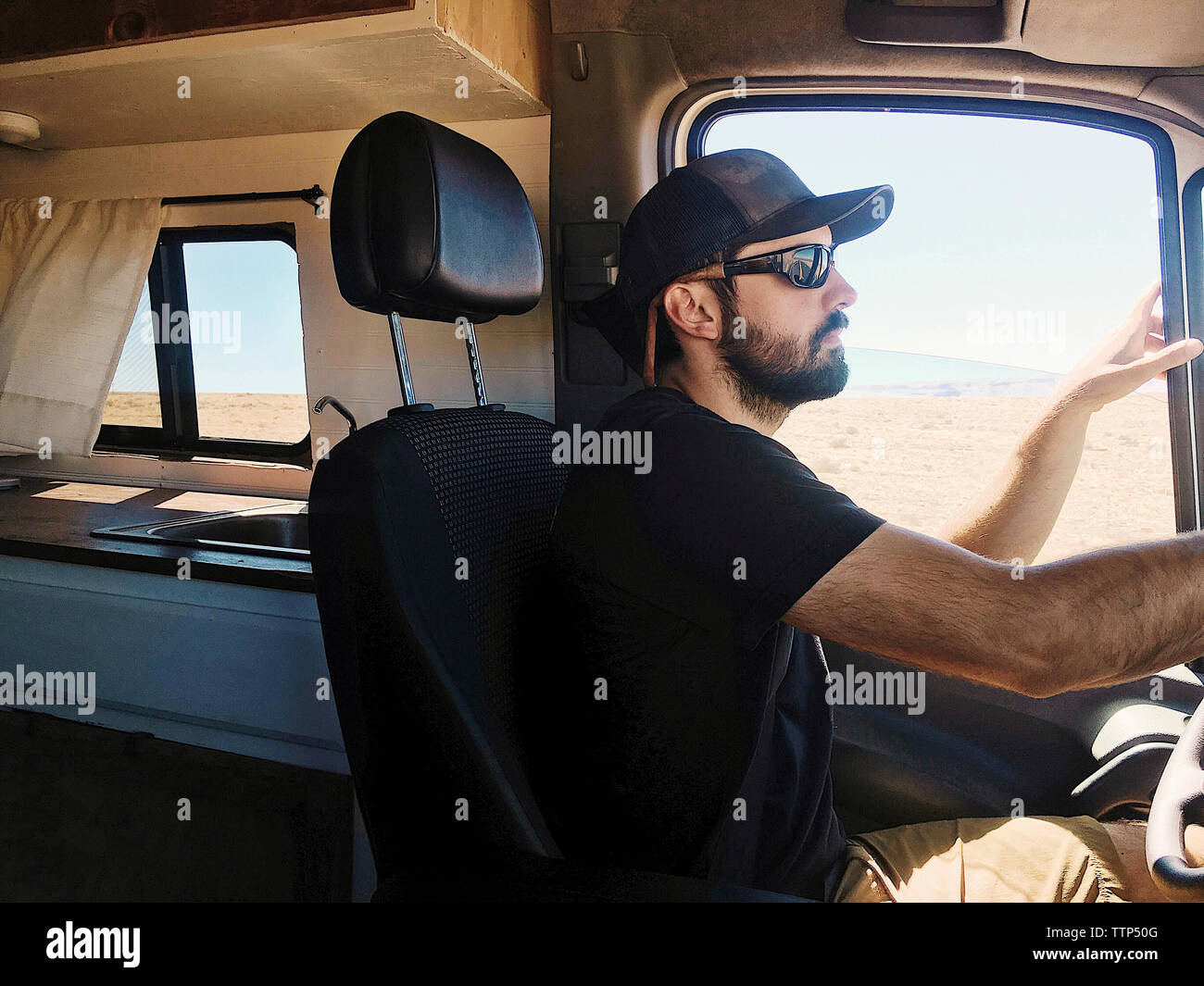 Side view of confident man driving motor home Stock Photo - Alamy