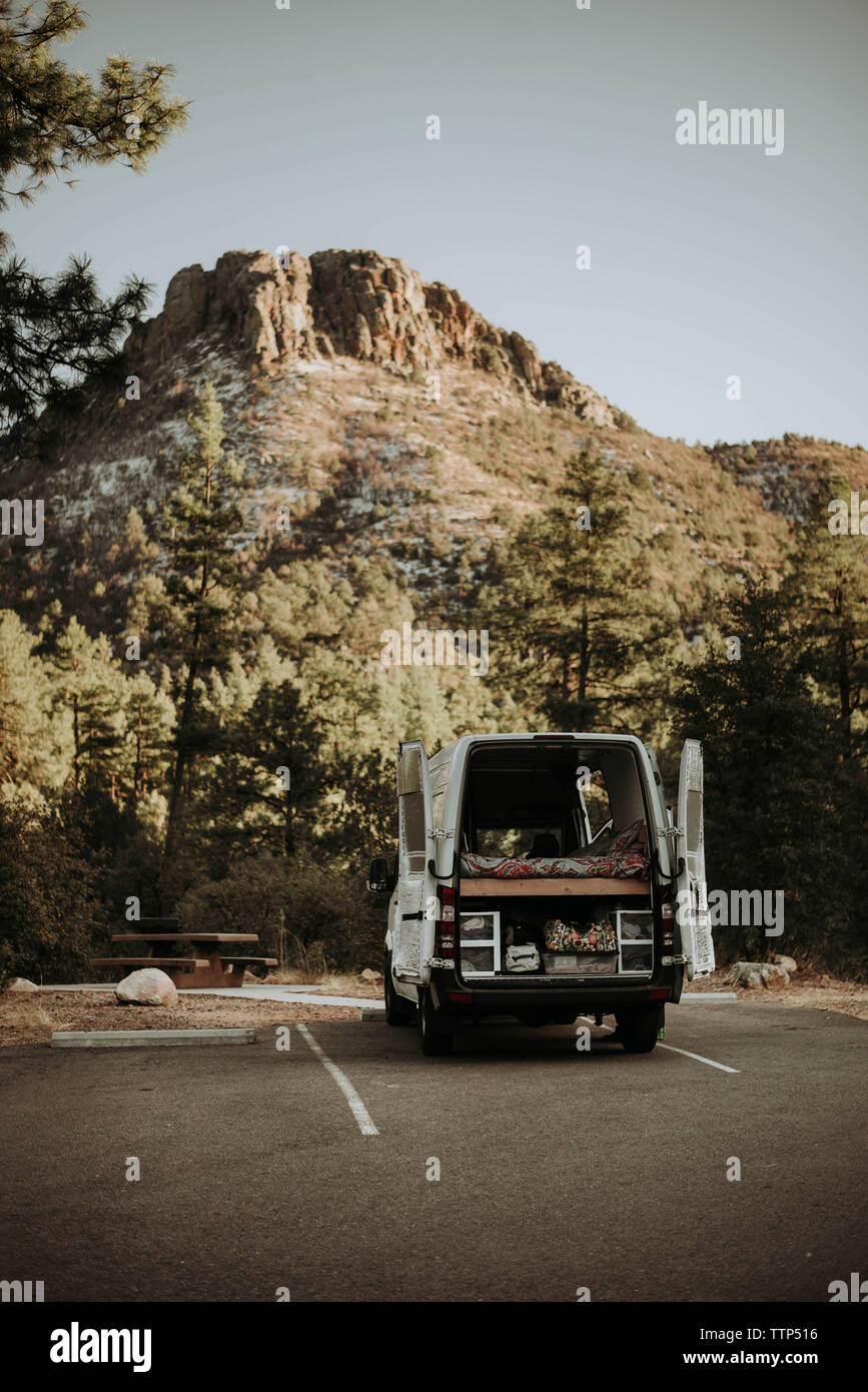 Motor home parked on road amidst mountain in forest Stock Photo