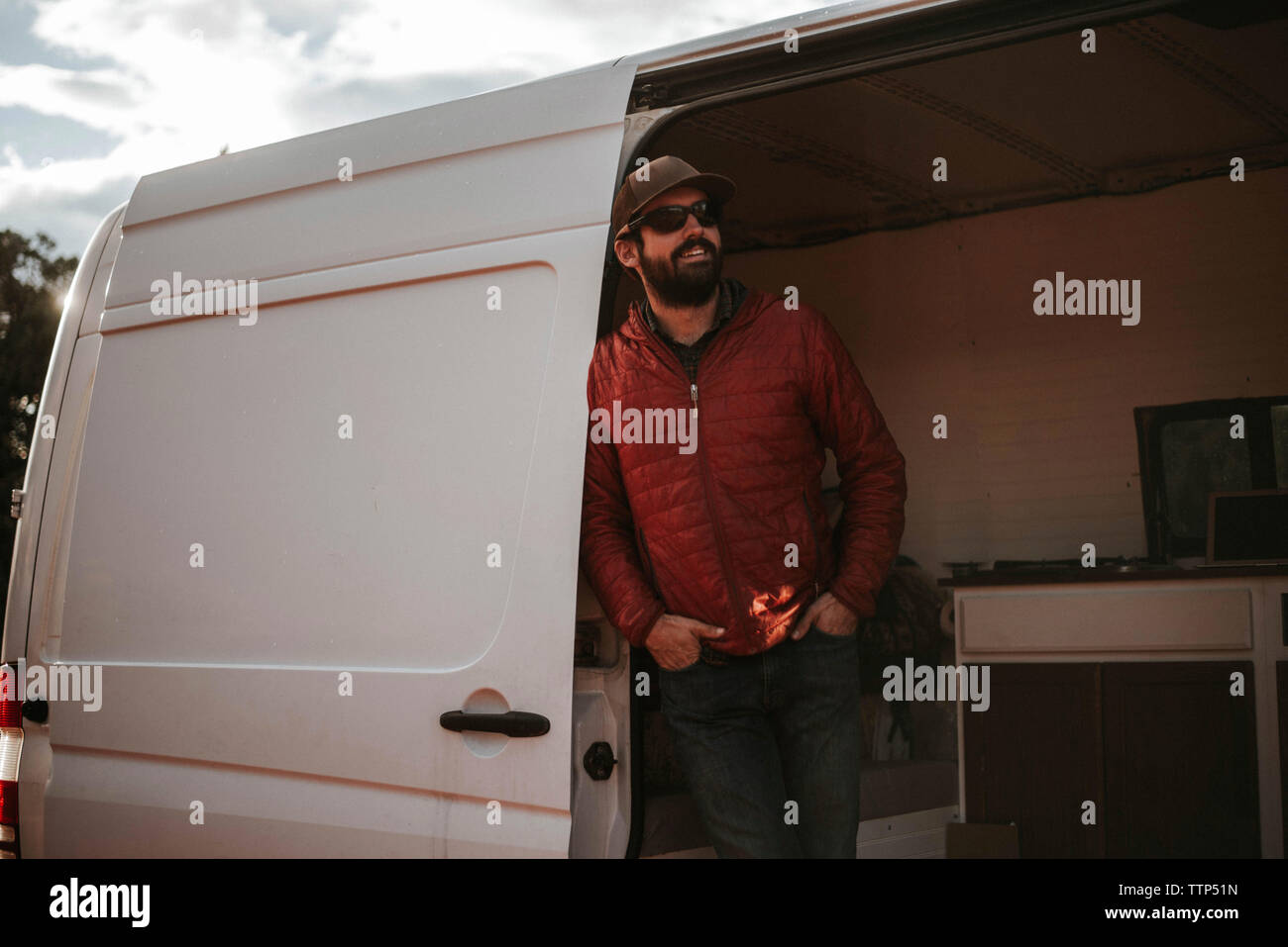 Man wearing cap and sunglasses while standing in motor home Stock Photo