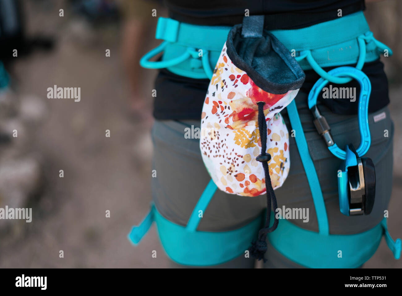 Midsection of woman wearing safety harness while standing outdoors Stock Photo