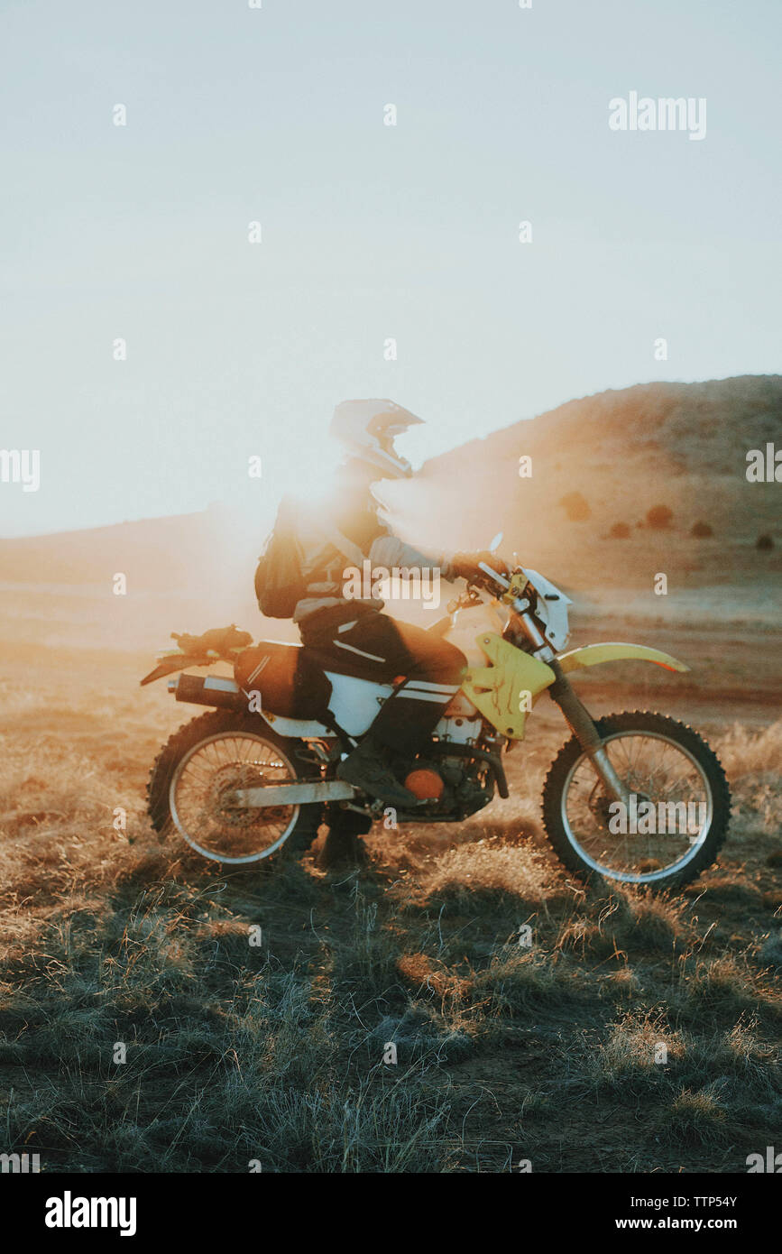 Man on motorcycle in desert during sunset Stock Photo