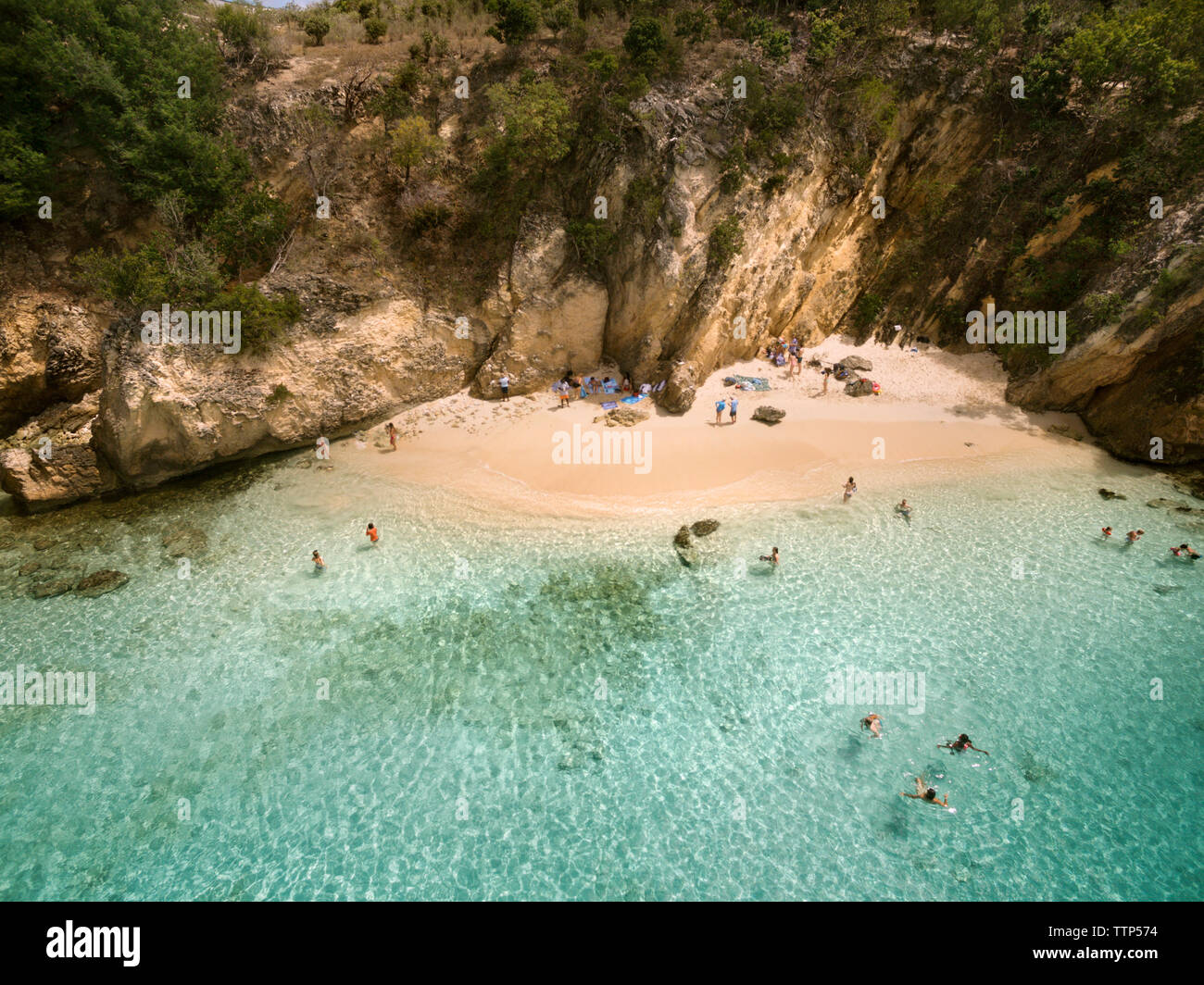 High angle view of people enjoying in sea against cliff Stock Photo