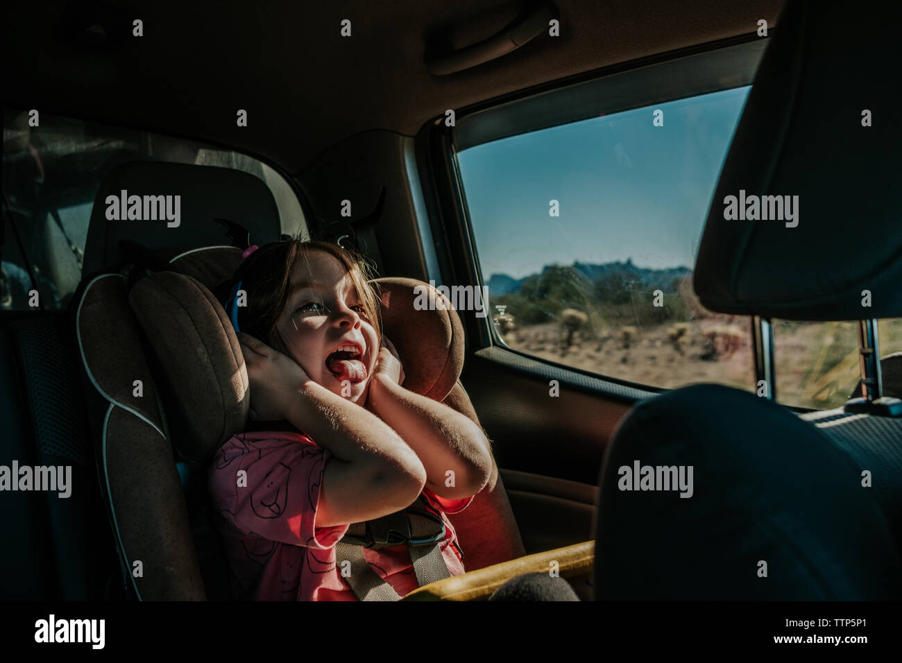Girl in a carseat, on a road trip through California Stock Photo