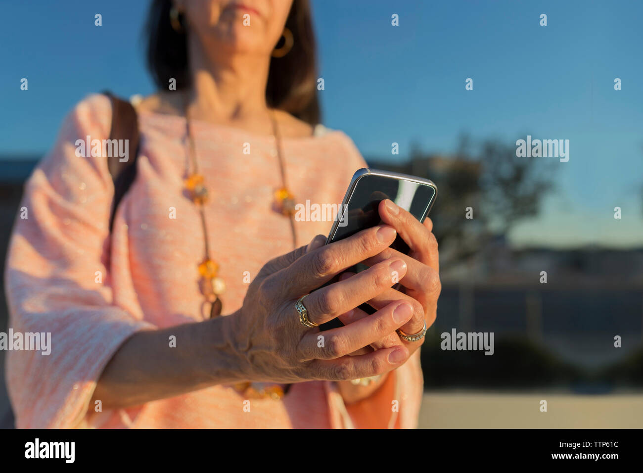 Midsection of woman using smart phone Stock Photo