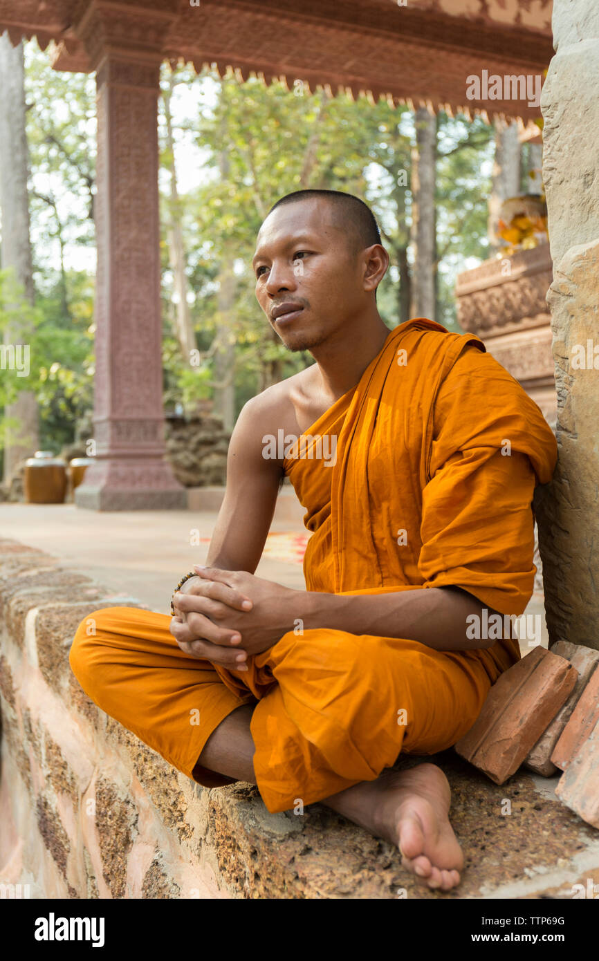 Monk in temple sitting on the wall Stock Photo