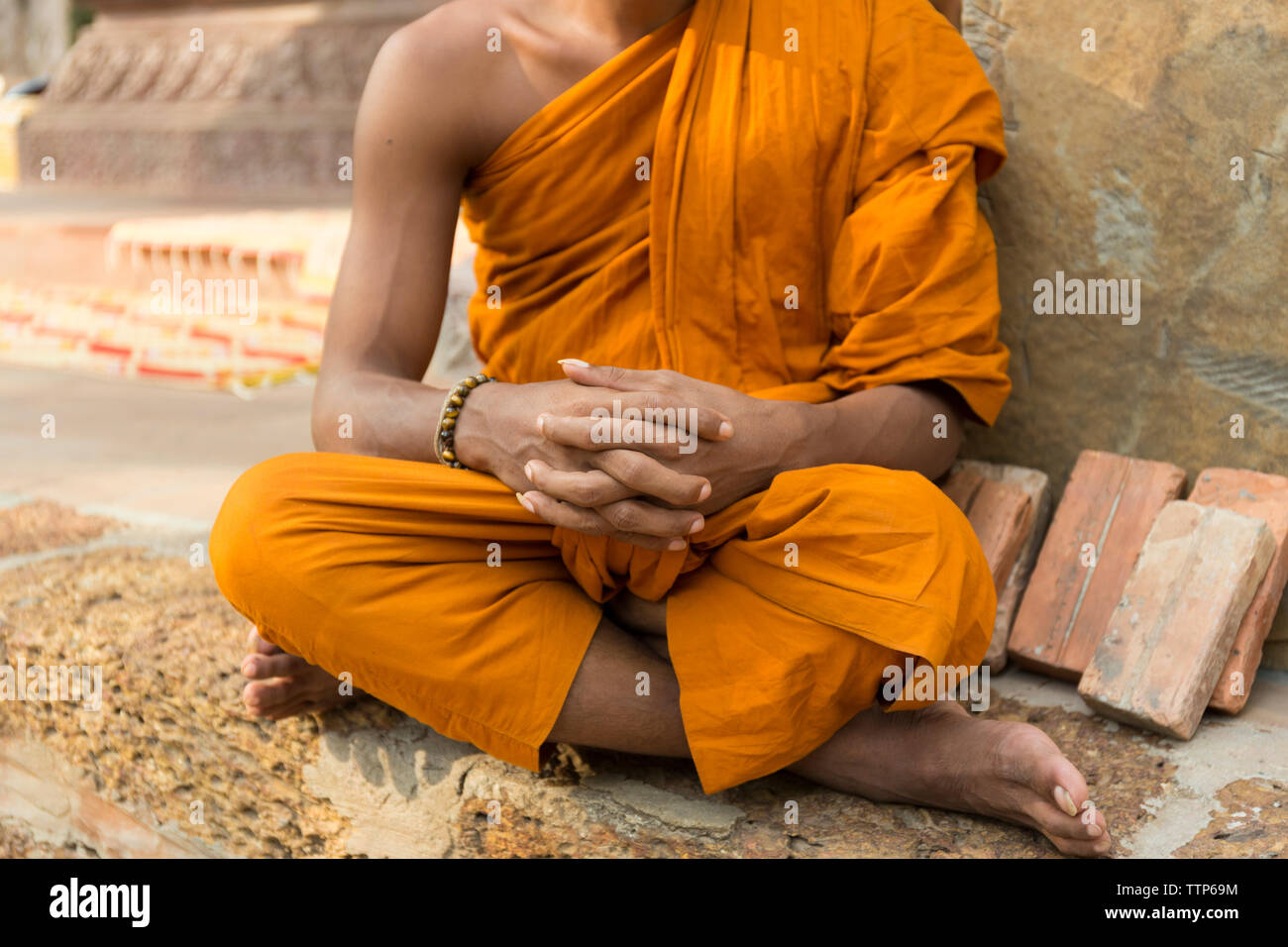 close up portrait of unrecognisable monk sitting in temple Cambodia Stock Photo
