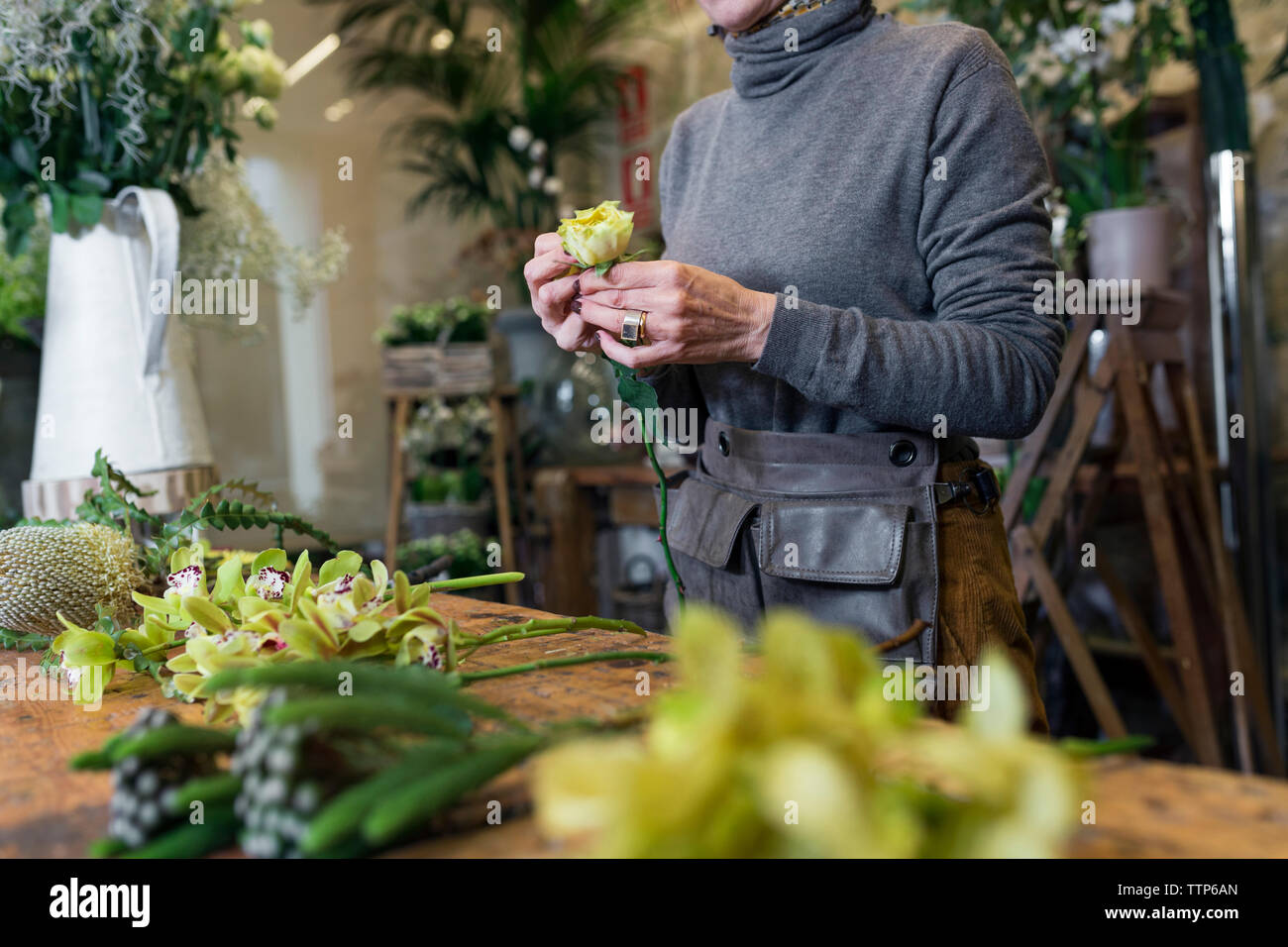 Unrecognisable woman working at flower shop desk Stock Photo - Alamy