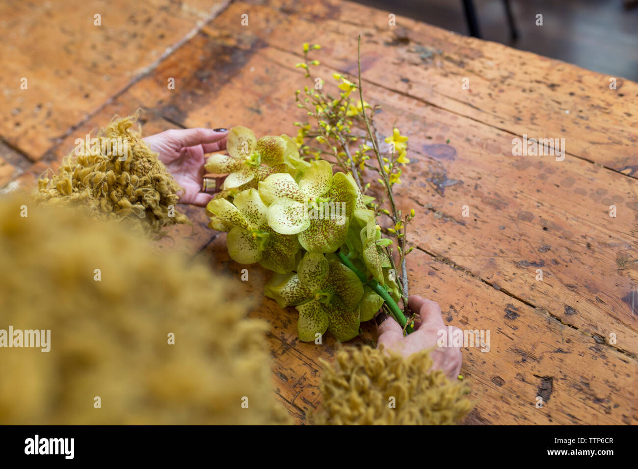 Unrecognisable woman holding yellow flowers at flower shop desk Stock Photo