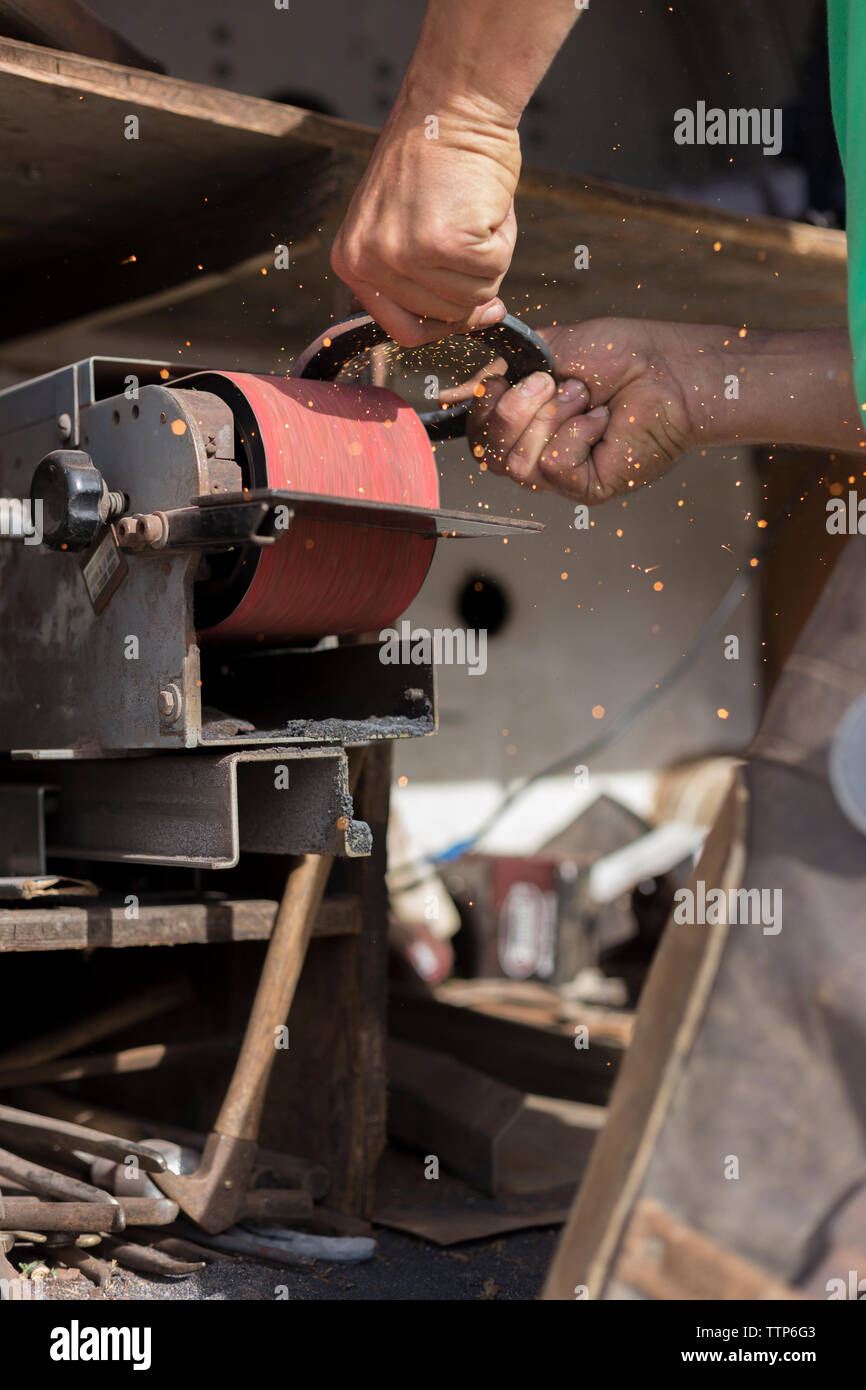 Close up of farrier grinding horseshoe Stock Photo