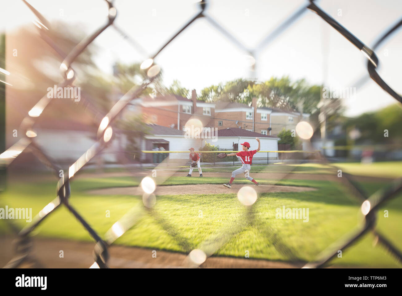 Full length of baseball player throwing ball while playing on field