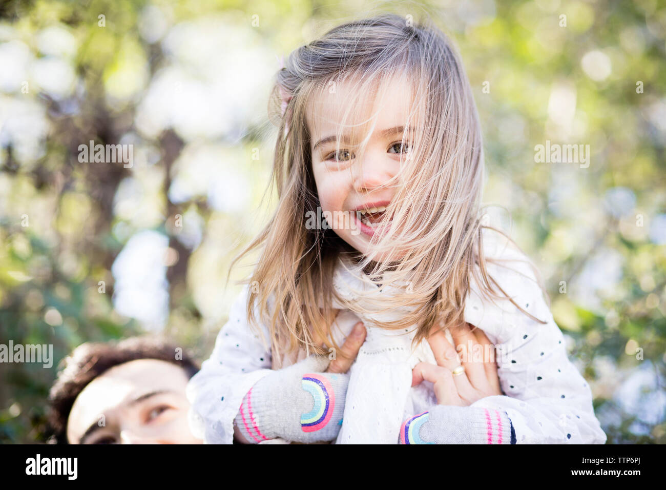 Cropped image of father picking up cute daughter in yard Stock Photo