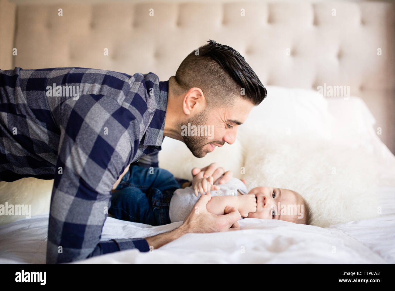 Side view dad looking at baby boy indoors Stock Photo