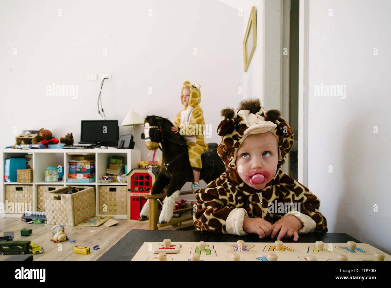 Siblings in animal costumes playing at home Stock Photo