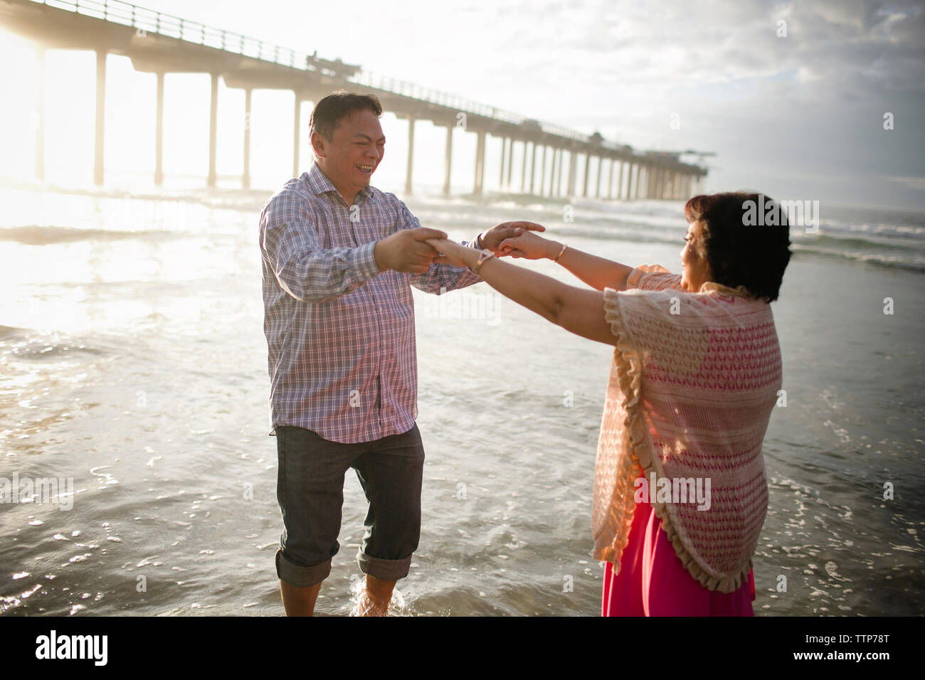 Couple dancing on shore at beach Stock Photo