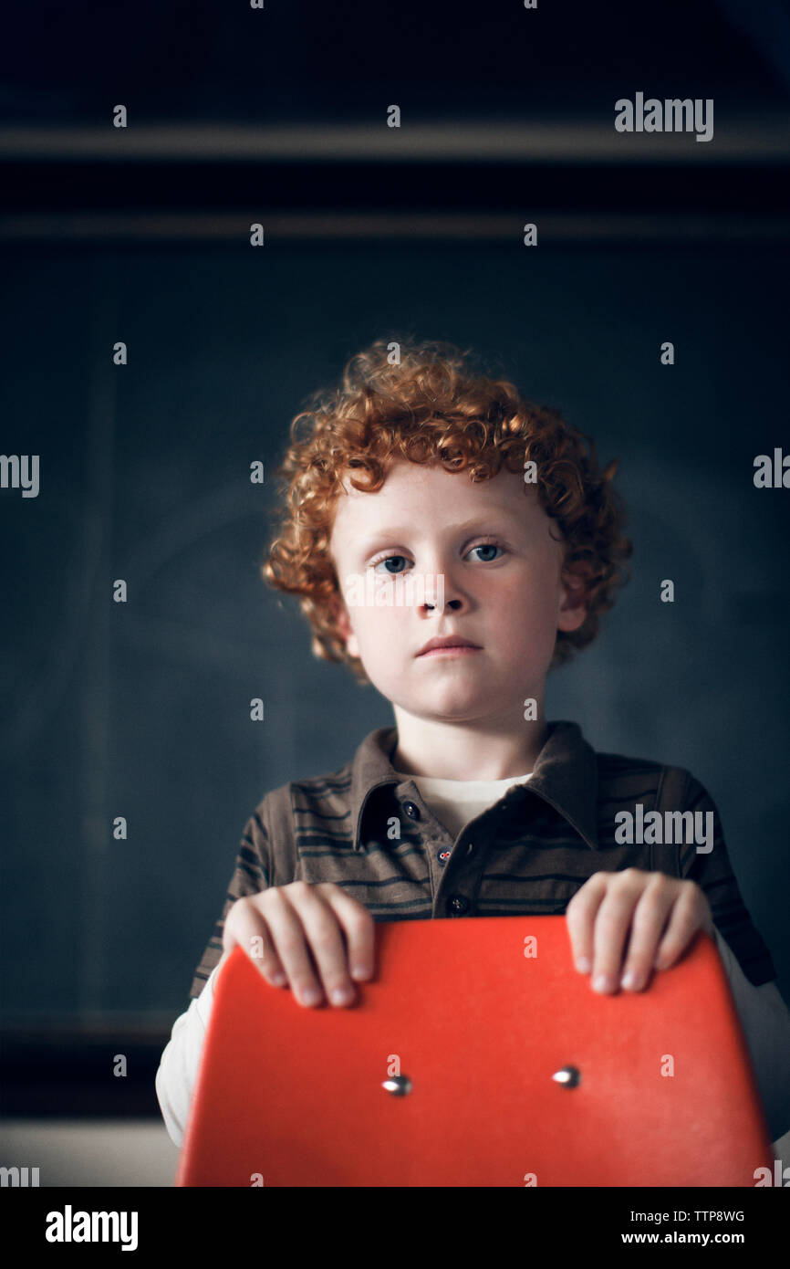 Portrait of boy standing behind chair at classroom Stock Photo Alamy