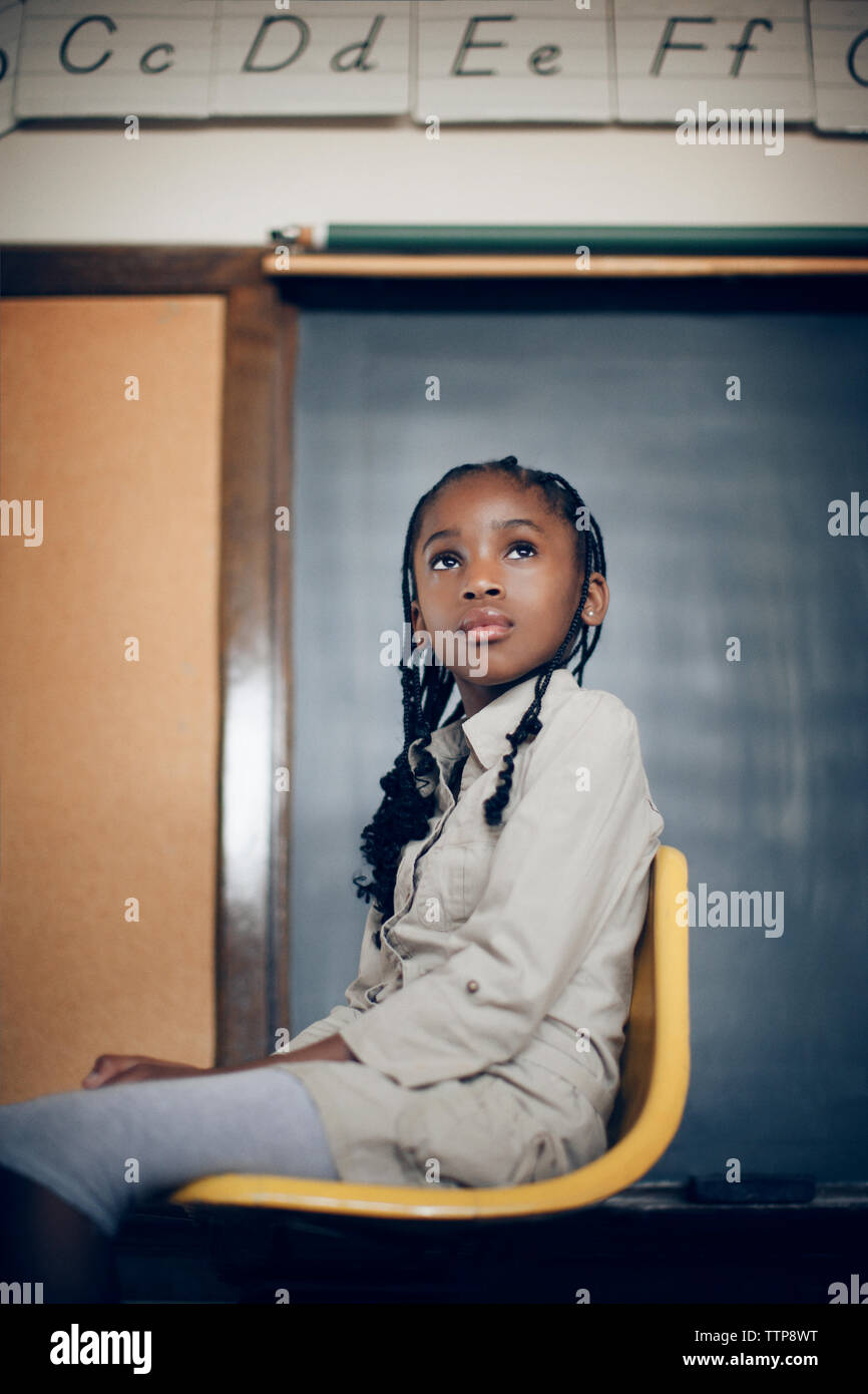 Low angle view of girl sitting on chair at classroom Stock Photo - Alamy