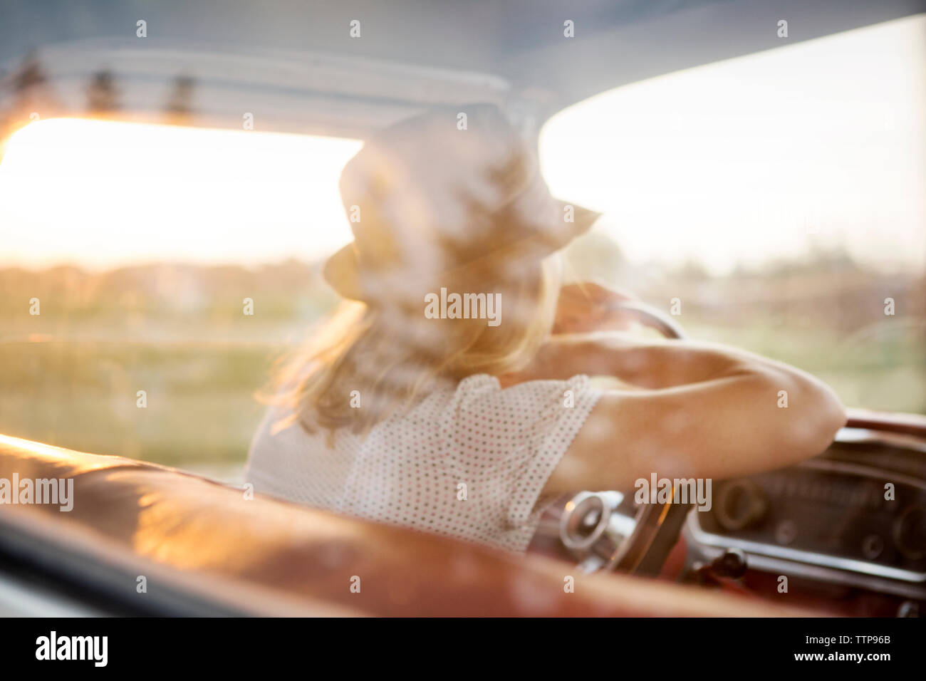 Rear view of woman leaning on steering wheel in car Stock Photo Alamy