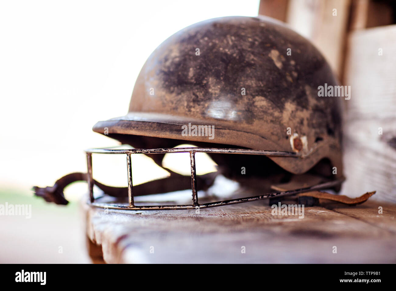 Close-up of dirty sports helmet on retaining wall Stock Photo