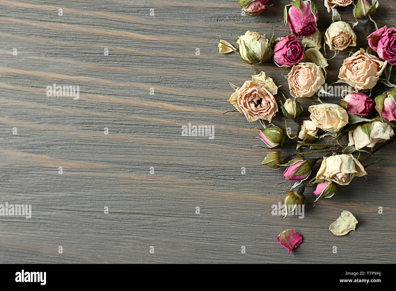 Dried rose buds on wooden background Stock Photo - Alamy