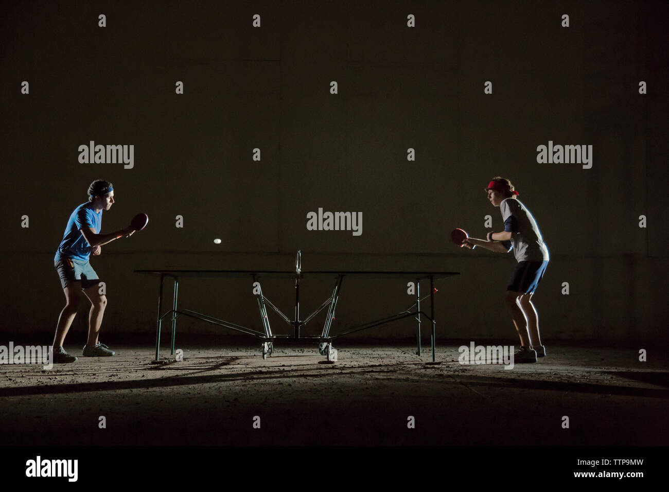 Male friends playing table tennis against building Stock Photo Alamy