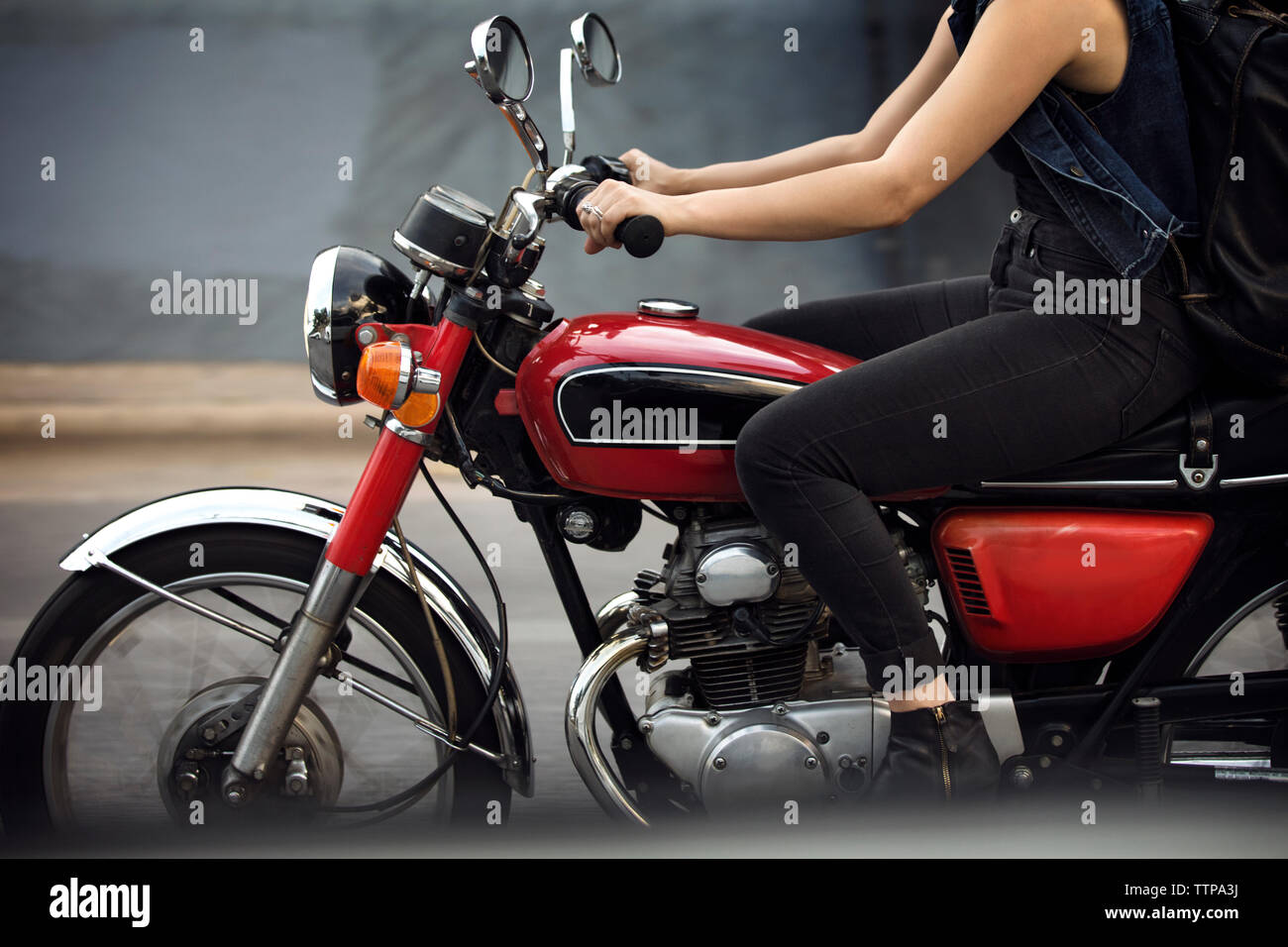 Low section of woman riding motorcycle on road Stock Photo
