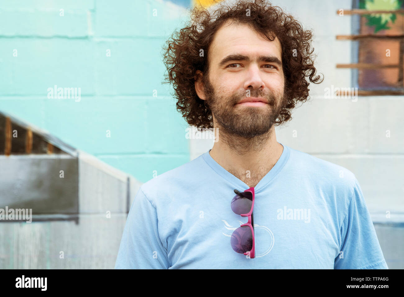 Portrait of smiling man standing against wall Stock Photo