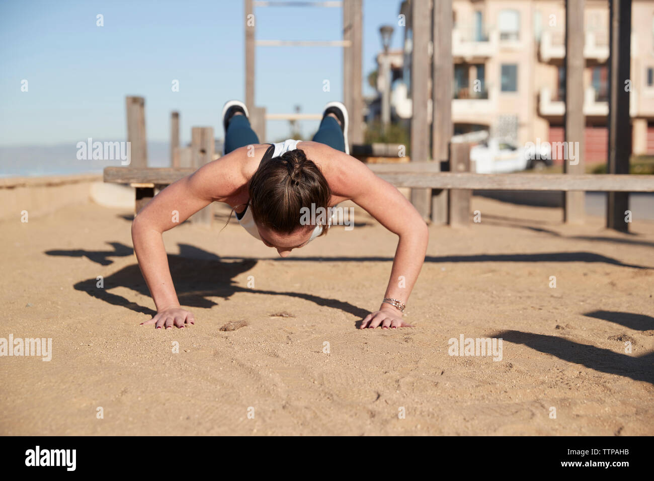 Woman doing push-ups at beach Stock Photo