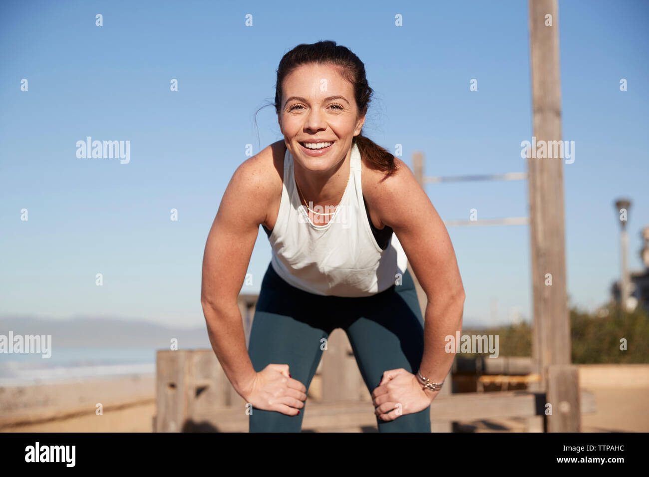 Portrait of smiling woman exercising at beach Stock Photo