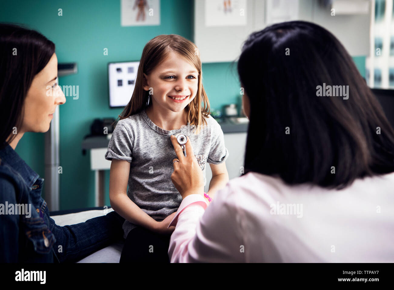 Cute girl being examined by female doctor in clinic Stock Photo