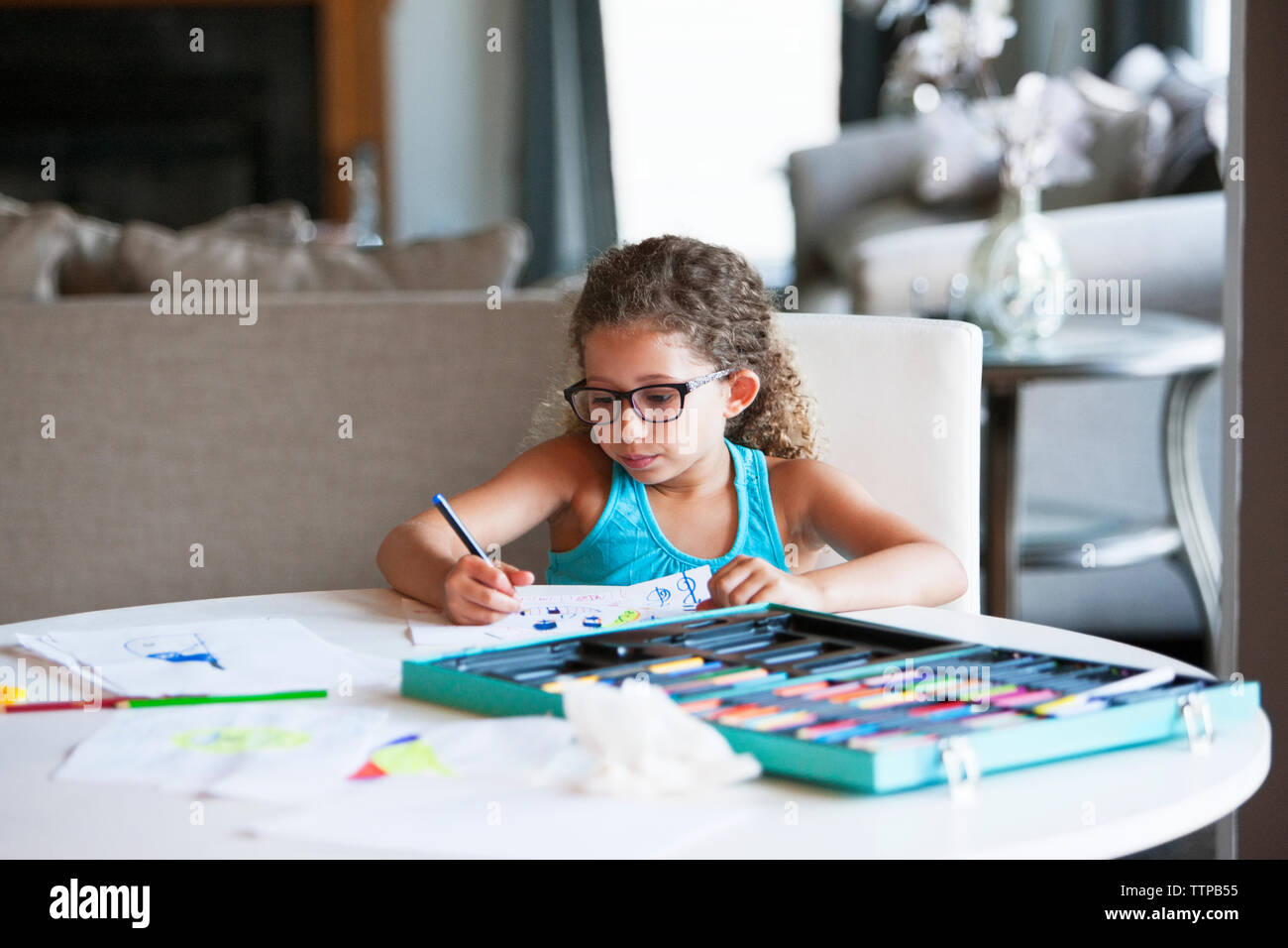 Girl coloring with felt tip pen on paper at table Stock Photo