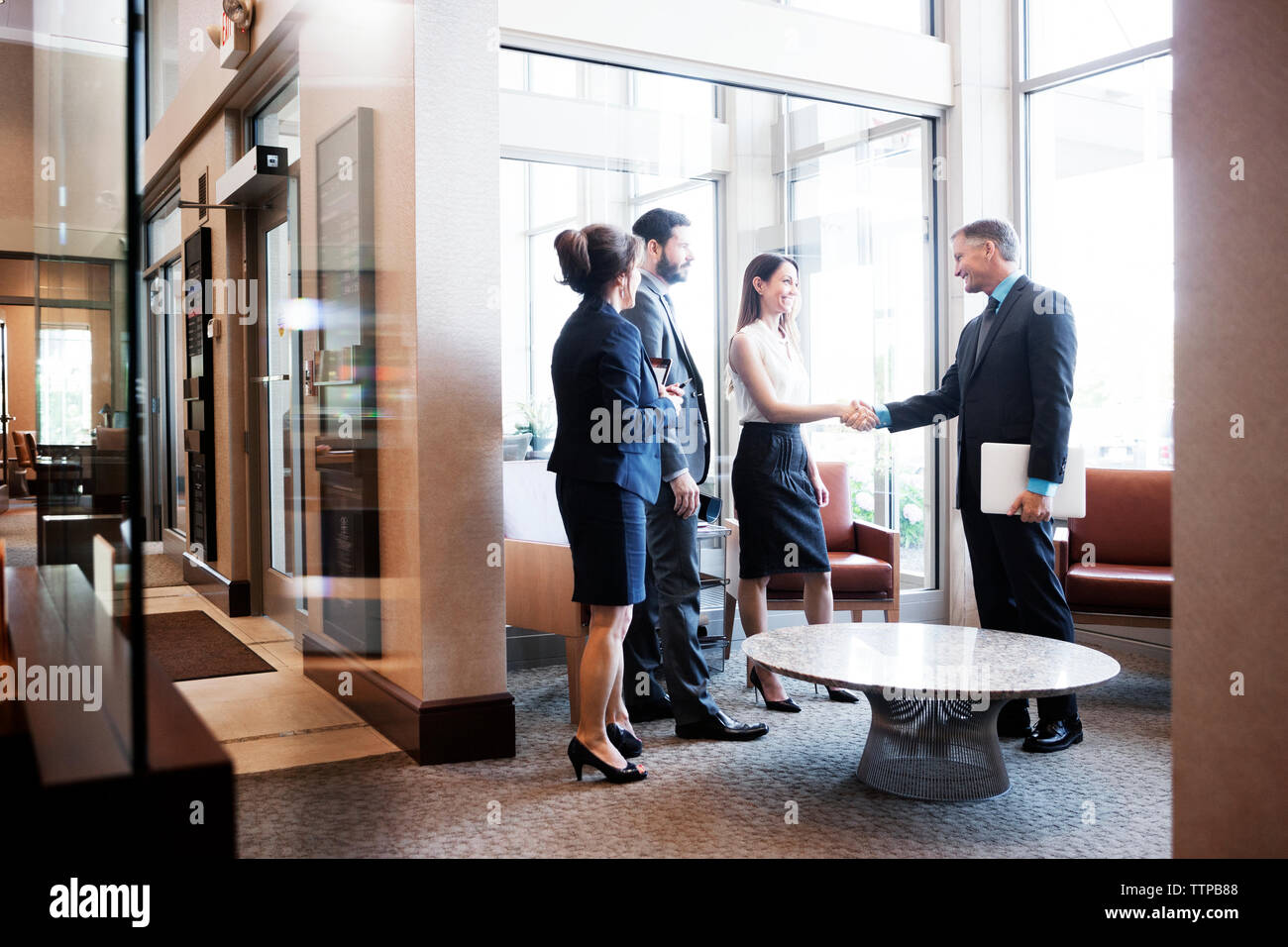 business people shaking hands at office lobby Stock Photo