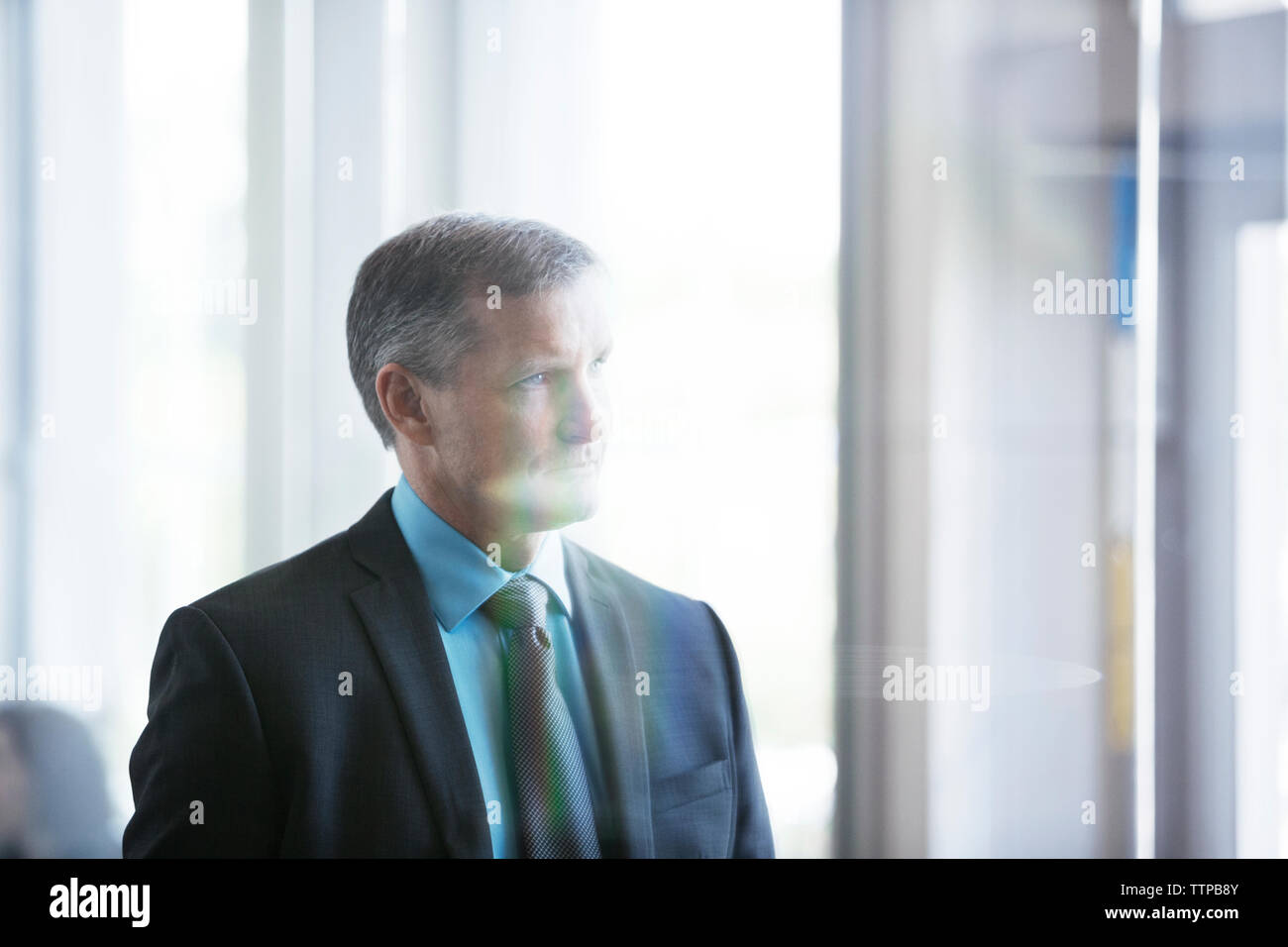 Thoughtful businessman standing in office Stock Photo