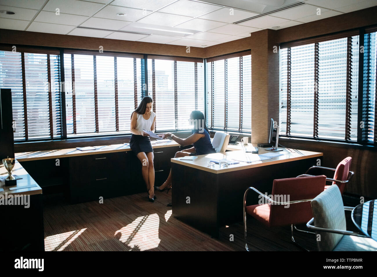 Female colleagues discussing reports in office Stock Photo
