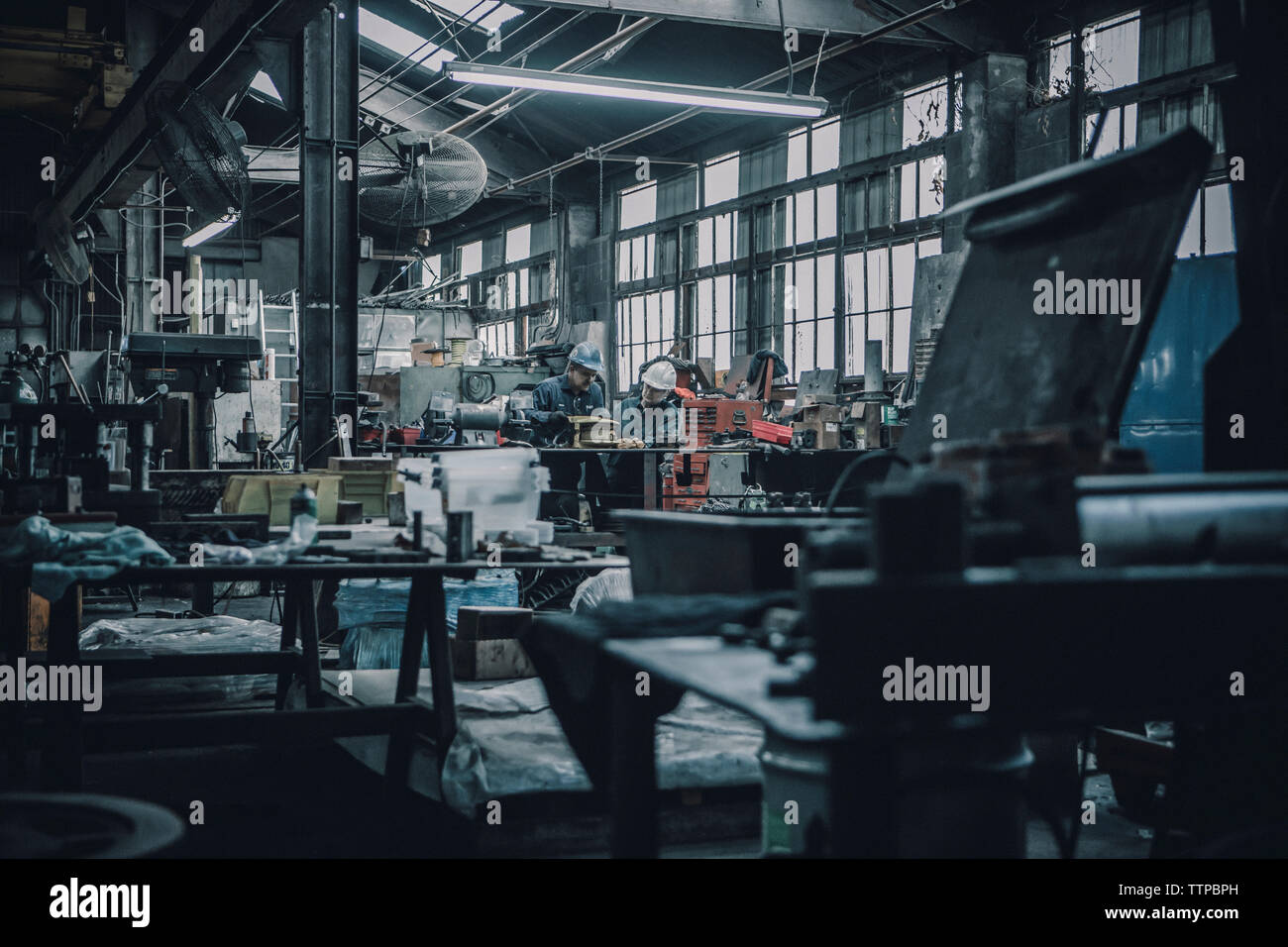 Mid distance view of workers working in metal industry Stock Photo