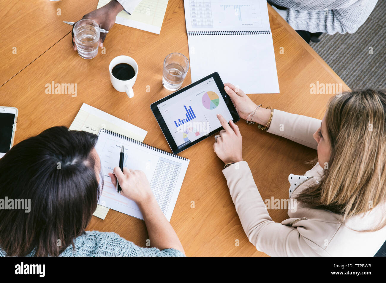 High angle view of businesswoman analyzing data with colleagues in meeting Stock Photo