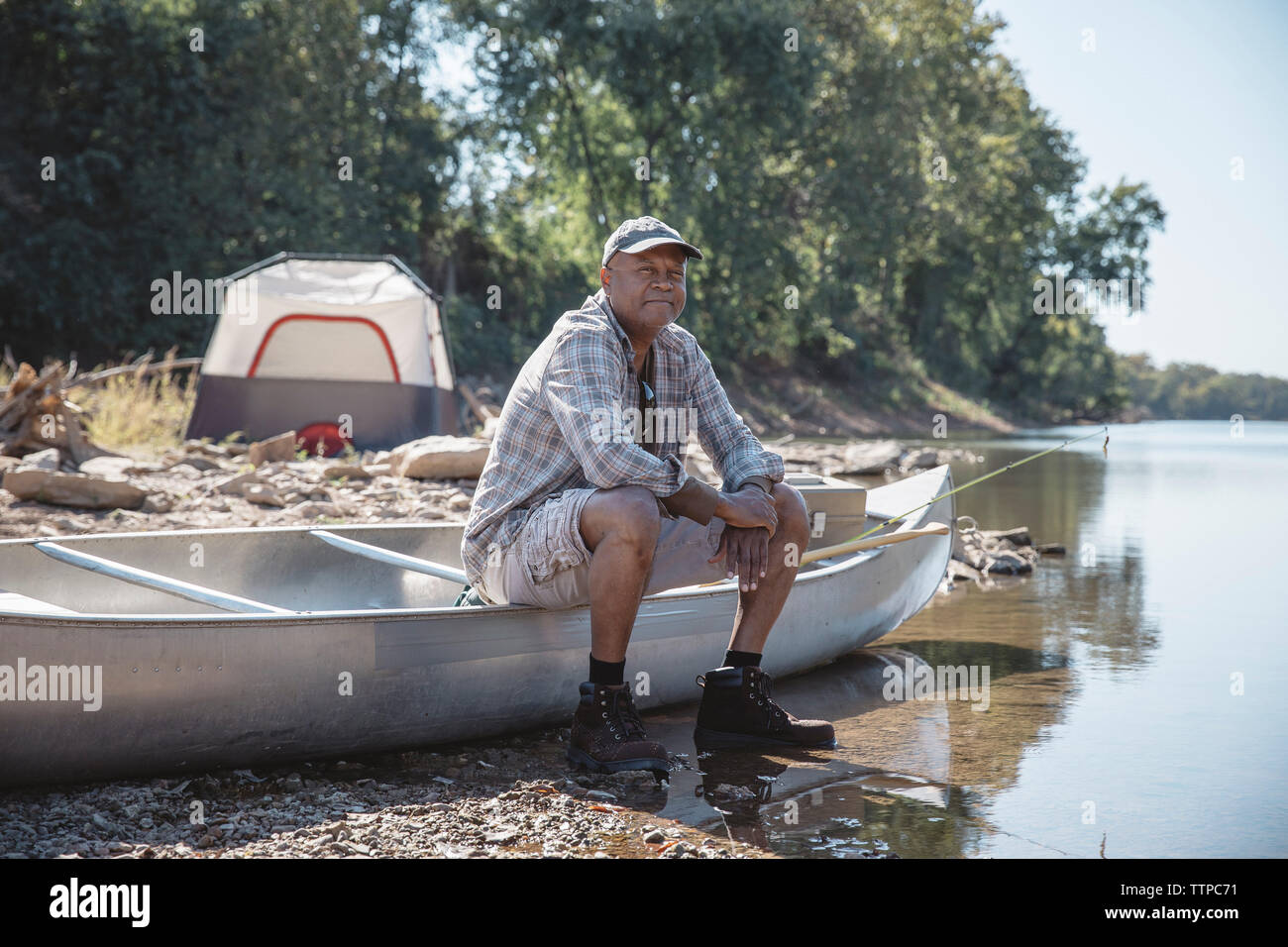 Portrait of man sitting on boat at lakeshore Stock Photo