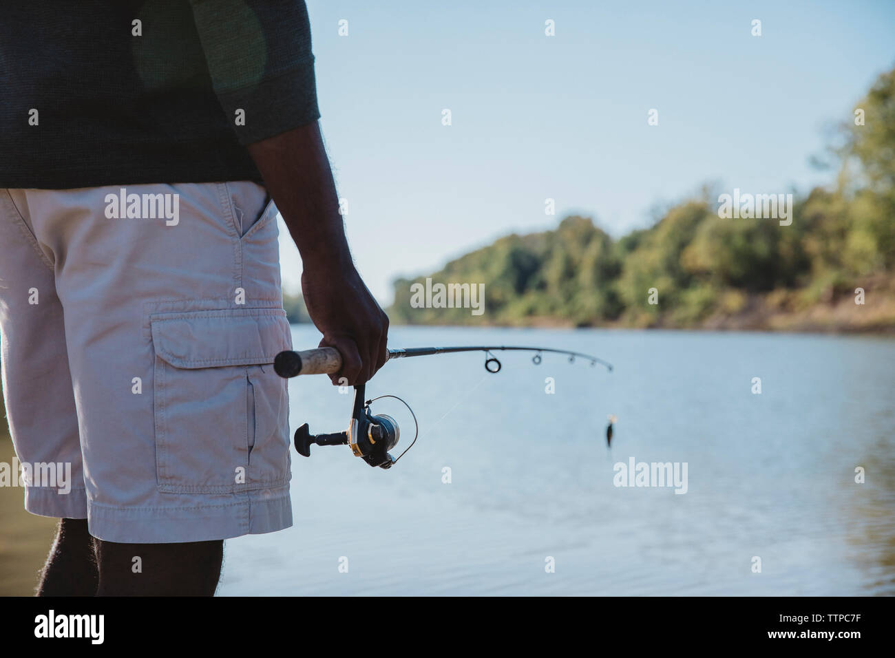 Portrait of bearded fisher man holding spinning casting rod standing on  bank waiting for bites on water river at summer day, looking at camera  Stock Photo - Alamy