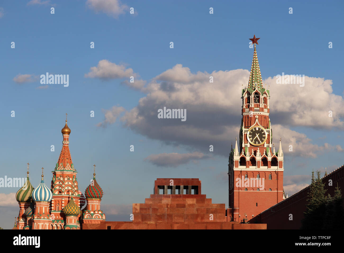 View to the Kremlin, St. Basil's Cathedral and Lenin mausoleum on Red Square in Moscow. Spasskaya tower against the blue sky with clouds Stock Photo