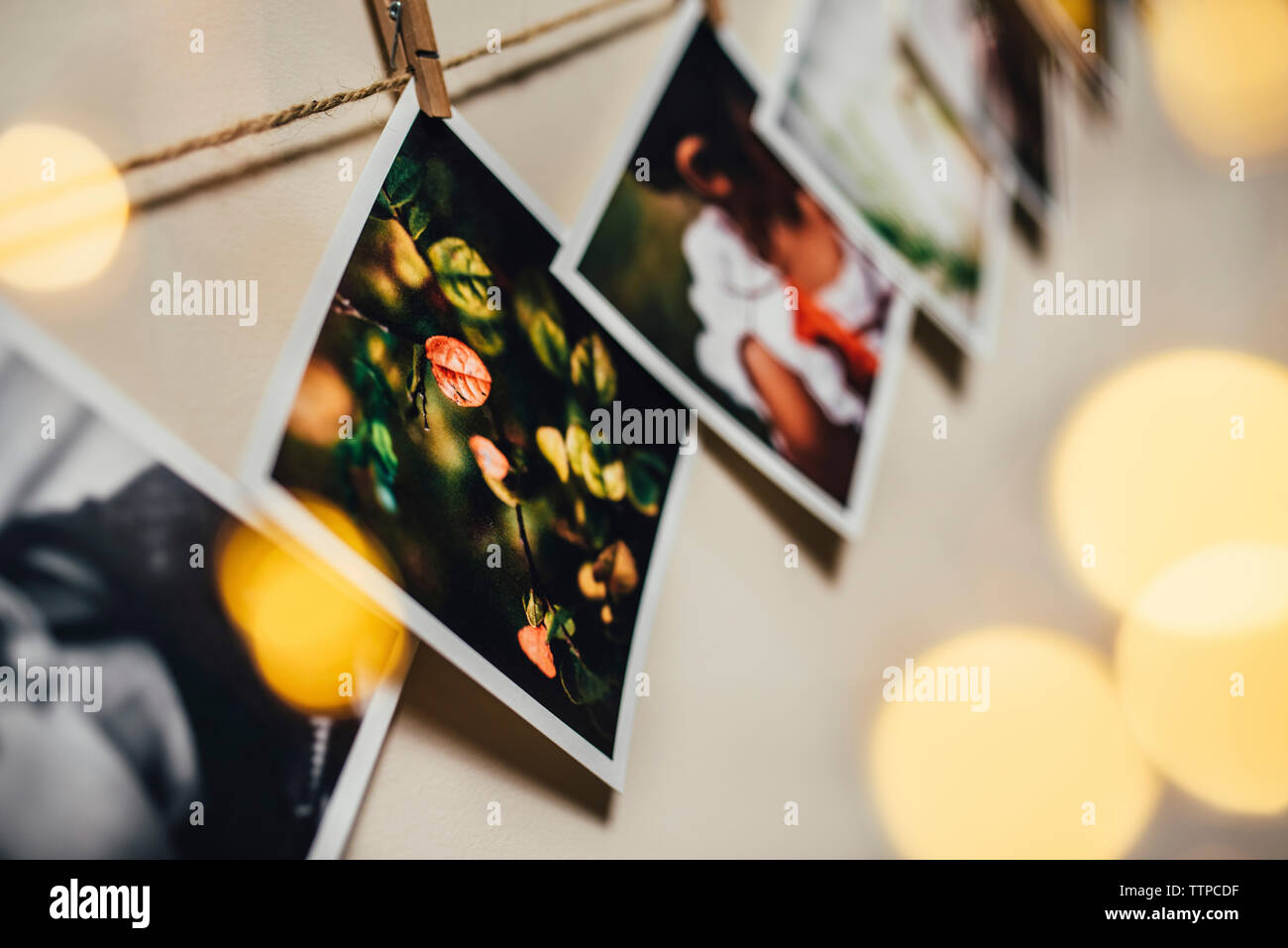 Low angle view of photographs hanging on rope against wall Stock Photo